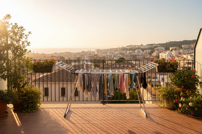 Stendibiancheria su balcone soleggiato con vista urbana - golden hour